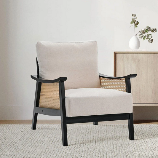 Black rattan lounge armchair in a modern living room setting.