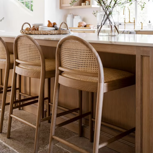 Solid Wood Rattan Bar Stools With Backs tucked under a modern rustic kitchen island