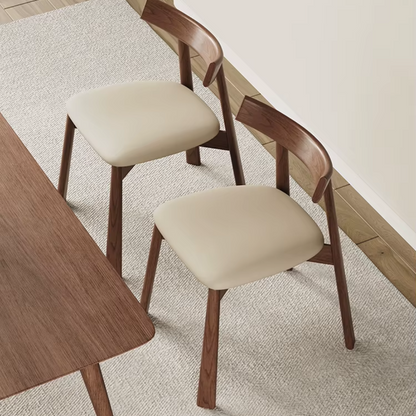 Close up of the leather upholstery and wooden frame detailing on a modern dining chair