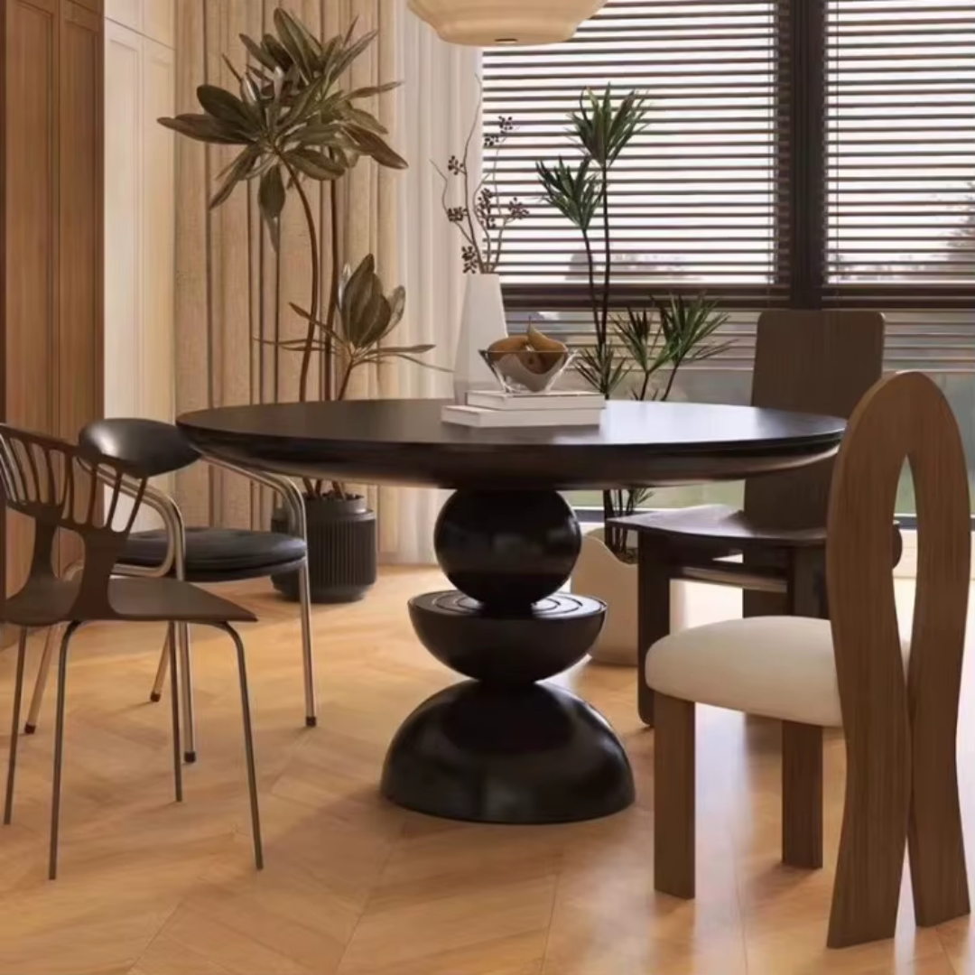 Round Black Pedestal Dining Table styled in a modern dining room with mid century style chairs